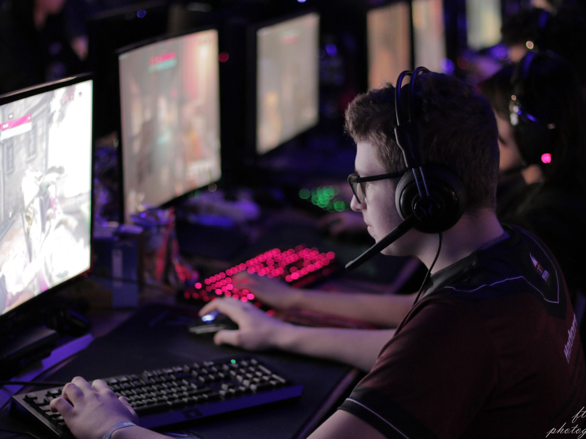 Esports arena packed with fans, vibrant lighting, and live Bitcoin betting odds displayed on large digital screens, capturing the excitement of crypto esports betting in 2024.